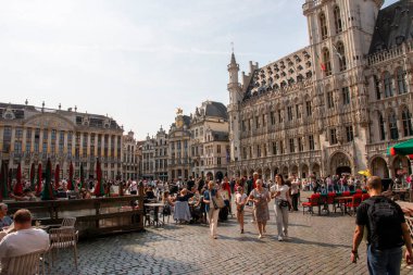 Brüksel, Belçika - 6 Ağustos 2025: İnsanlar tarihi binalarla dolu kalabalık bir meydanda boş vakitlerin tadını çıkarıyor.