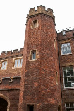 Tarihi bir ortamda yüksek bir tuğla kule ve pencereler.