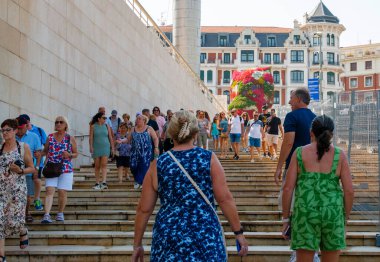 Bilbao, İspanya - 11 Ağustos 2025: İspanya 'da yaz yolculuğunun tadını çıkaran kalabalık Bilbao' daki merdivenlerden aşağı iniyor.