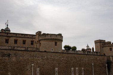 Londra, İngiltere - 7 Ağustos 2025: Ziyaretçiler gökyüzünün altındaki tarihi bir kalenin taş duvarlarına ve kulelerine bakıyorlar.