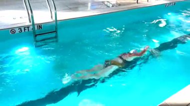 Kucak havuzunda yüzen bir kadına yaklaş..