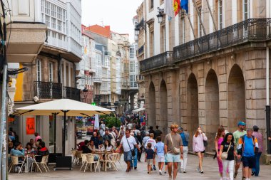 Coruna, İspanya - 12 Ağustos 2025: İnsanlar La Coruna 'da canlı bir sokakta geziniyor. Kafeler ziyaretçilerle dolu..