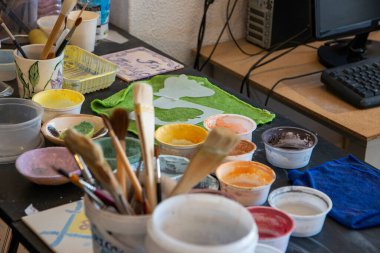 Porto 'da bir sanat projesi için renkli boya ve fırçalar bir masanın üzerine konur..