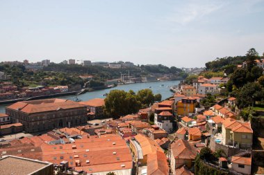 Sahne, güneşli bir günde Porto 'nun çatılarında nehir ve tekneler gösteriyor..
