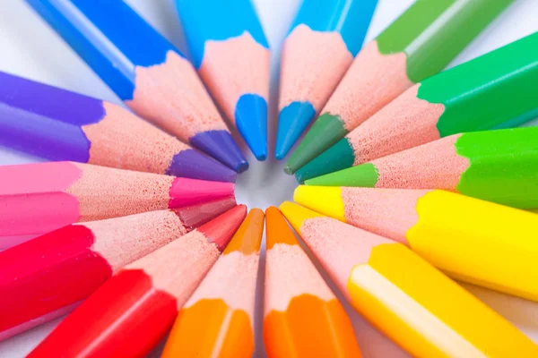 Colored pencils arranged round figure — Stock Photo, Image