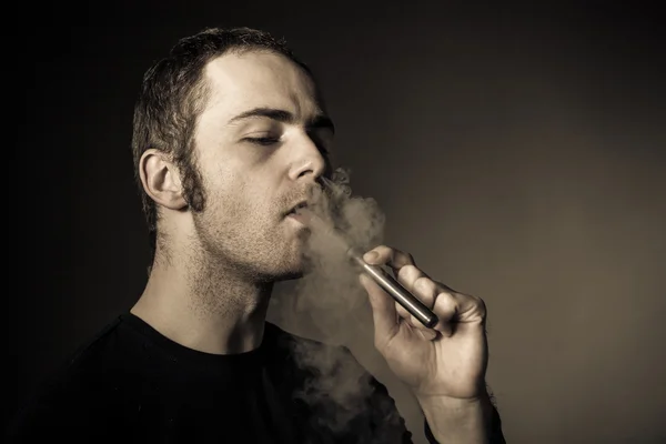 Man smokes electronic cigarette — Stock Photo, Image