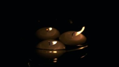 Süper yavaş çekimde uçan mumların bir bardakta üflemesi ve diriltilmesi. Önce mum ışıkları sönüyor, ama sonra tekrar parlamaya başlıyor..