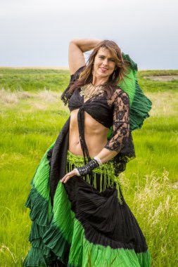 Siyah bir üst ve yeşil elbiseli kadın 