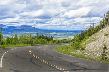 The mountain highway through the Canadian Rockies near Waterton Lakes National Park. clipart