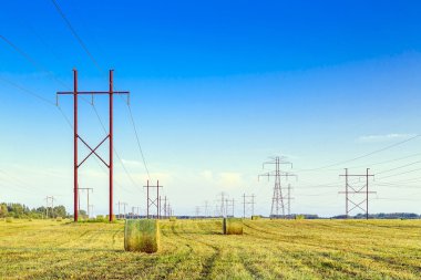 Güç iletim kule ve elektrik hatları üzerinden balya sahip bir alan üzerinde gökyüzü.