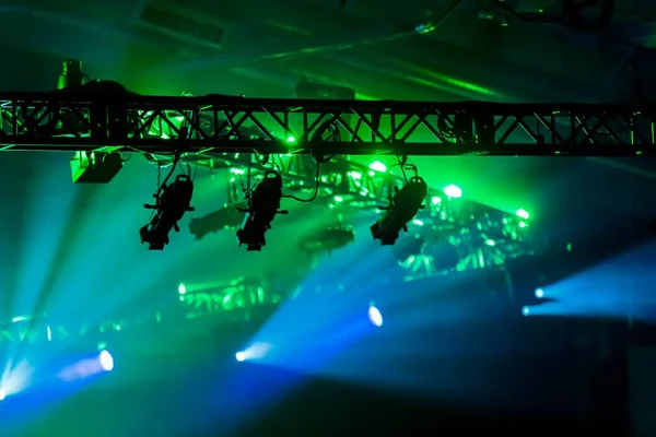 Stage lighting from overhead with green and blue lights.