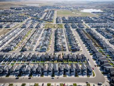 Saskatchewan, Saskatoon 'daki Brighton hava manzarası, renkli sonbahar ağaçları, evler ve göletleri gösteriyor..