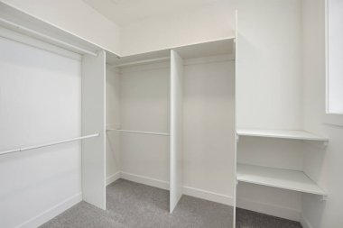 White closet with shelves and a shelf in the corner. The closet is empty