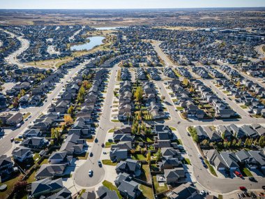 Saskatchewan, Saskatoon 'daki Stonebridge hava manzarası renkli devrilmiş ağaçları ve modern evleri gösteriyor..