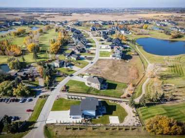 Saskatchewan Saskatoon yakınlarındaki Greenbryre 'in havadan görünüşü, evlerin ve golf sahasının sonbahar renklerini gösteriyor..