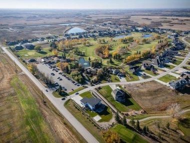 Saskatchewan Saskatoon yakınlarındaki Greenbryre 'in havadan görünüşü, evlerin ve golf sahasının sonbahar renklerini gösteriyor..