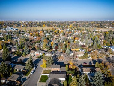 Saskatchewan, Saskatoon 'daki Lawson Tepeleri' nin hava manzarasında nehir kenarındaki renkli devrilmiş ağaçlar ve evler yer alıyor..