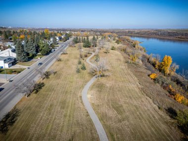 Saskatchewan, Saskatoon 'daki Lawson Tepeleri' nin hava manzarasında nehir kenarındaki renkli devrilmiş ağaçlar ve evler yer alıyor..