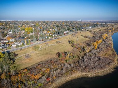 Saskatchewan Saskatoon 'daki Silverwood Tepeleri' nin havadan görünüşü, nehir kenarındaki renkli devrilmiş ağaçlar ve evler..