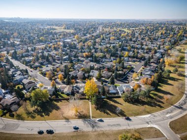 Saskatchewan Saskatoon 'daki Silverwood Tepeleri' nin havadan görünüşü, nehir kenarındaki renkli devrilmiş ağaçlar ve evler..