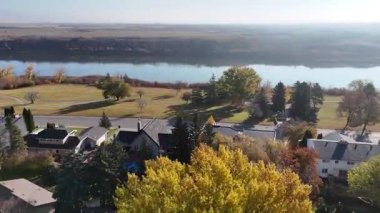 Lawson Heights Saskatoon 'un sonbaharda çekilmiş hava görüntülerinde nehir boyunca renkli ağaçlar, parklar ve evler görülüyor..