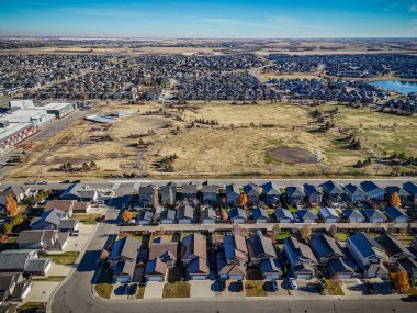 Saskatchewan, Saskatoon 'daki Stonebridge hava manzarası renkli devrilmiş ağaçları, evleri ve parkları gösteriyor..