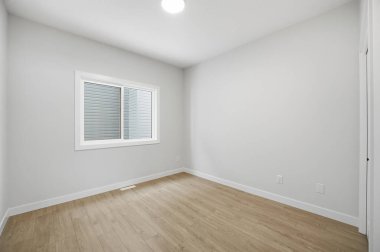 Penceresi ve kapısı olan çok boş bir oda. Oda çok temiz ve çok basit bir tasarımı var.