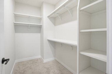 Rafları ve kapısı olan beyaz bir dolap. Dolap boş ve temiz. Dolabın beyaz rengi sakinlik ve basitlik hissi veriyor.