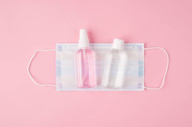 Sağlık sigortası konsepti. Yukarıdaki tepede düz görünüm maske ve dezenfektanların fotokopi uzaylı pembe arka planda izole edilmiş fotoğrafları var.