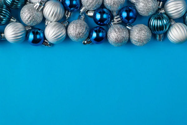 Christmas is coming soon concept. Top above overhead view close up photo of beautifully decorated blue baubles isolated on blue background with copyspace