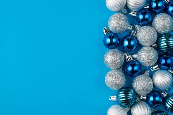 Christmas is coming soon concept. Top above overhead view close up photo of beautifully decorated blue baubles placed to the right side isolated on blue background with copyspace