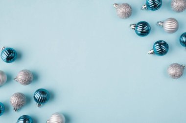 Köşelerde duran, içi boş fotokopi alanı olan, izole edilmiş pastel mavi arka planda duran ağaç oyuncak toplarının yakın plan fotoğrafı.