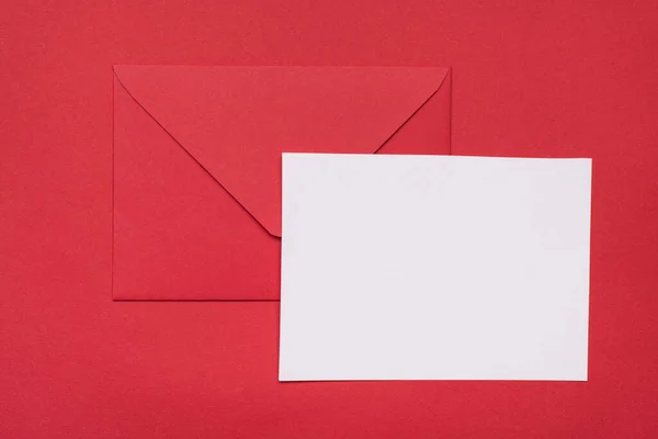 近景照片红色信封和空白空白白纸隔离明亮的红色背景 — 图库照片
