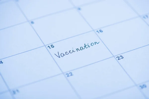 Vaccination concept. Close up view photo of word vaccination written on calendar cell