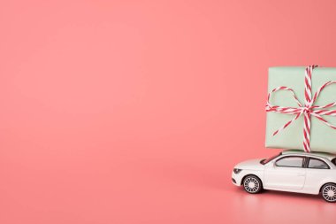 Mutlu kadınlar günü konsepti. Yan profil yakın görünüm beyaz mini modern arabanın üst çatıda büyük bir paket taşıyan izole ışık pastel renk arkaplan boş boşluk