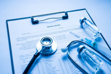 Doktor masasında duran cam şişe ve şırıngayla panonun fotoğrafını kapat.