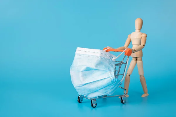 Go shopping only with mask concept. photo of responsible wooden man carrying basket wearing disposable hygienic mask filter isolated pastel color blue backdrop