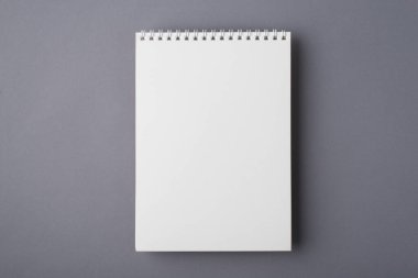 Yukarda düz bir şekilde yatıyordu. Tasarım için izole edilmiş gri masa için temiz spiral not defterinin görüntüsünü taklit et.