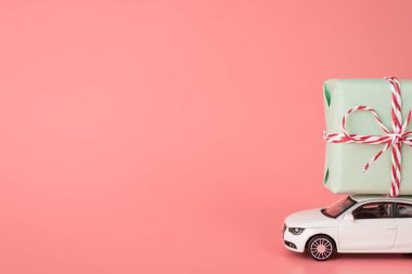 Uluslararası Kadınlar Günü konseptin kutlu olsun. Yan profil, modern mini arabanın çatıda büyük bir turkuaz renk kutusu taşıyan boş boşluklu, izole edilmiş açık pembe arkaplan fotoğrafı.