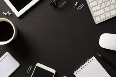 Ofis eşyalarının düz açılı fotoğrafının üzerinde gözlüklü klavye faresi cep telefonu kahve not defteri boş boş boş merkez izole edilmiş siyah arkaplan