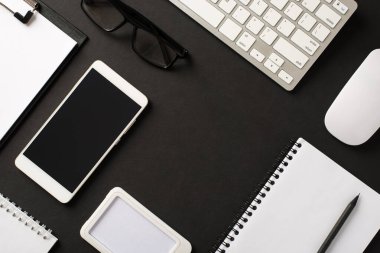 Çizim metni izole edilmiş siyah arkaplan için merkezinde boş alan olan planlayıcı klavye gözlüklü cep telefonlu eşyaların ofis fotoğrafının üzerinde düz bir şekilde yatıyordu