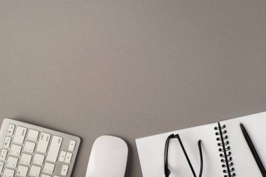 Klavye bilgisayarı fare defterinin üstünde siyah kalem ve boş arkaplanda izole edilmiş gözlükler.