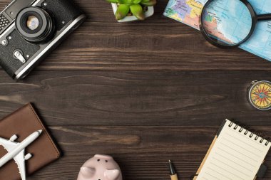 Piggy Bank Uçak Model Kamera Haritası büyüteç pasaport kaplama kalem fabrikası ve not defteri izole ahtan masa arkaplanı ve ortası kopyalanmış