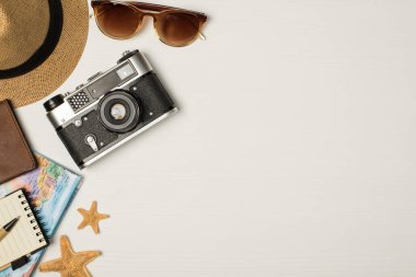 Başlık fotoğrafının üst görüntüsü kamera pasaport kapağı yıldız balıkları kalem ve not defterleri izole edilmiş ahşap arkaplan ve sağ telif alanı