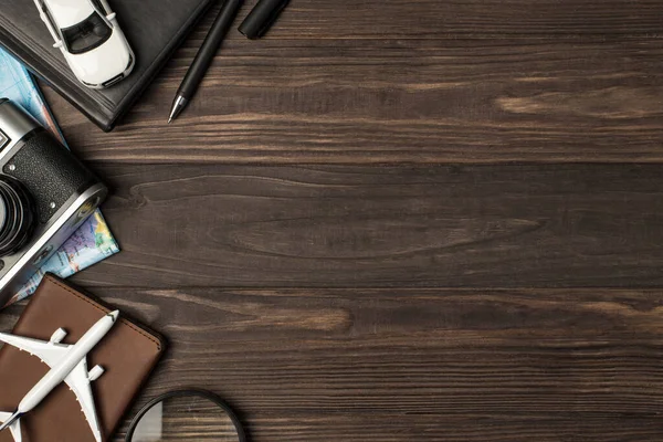 Araba ve uçak modellerinin en iyi görüntüsü pasaport kalem büyüteç kamerası ve sağ arka plandaki izole ahşap masa arkaplanının haritasını kaplar.