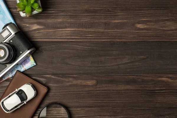 Pasaport kapağındaki araba modelinin en iyi görüntüsü bitki büyüteç kamerası ve sağında telif alanı olan izole ahşap masa arkaplanındaki harita.