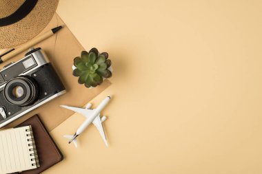Şapka yerleştirme kalem defteri pasaport kapak modeli ve el işi kağıt zarf üzerinde kamera izole edilmiş bej arkaplan ve kopyalanmış