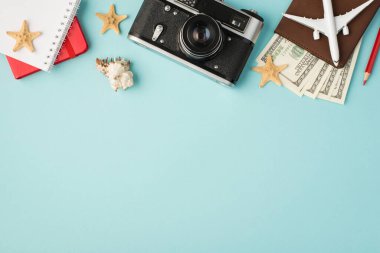 Pasaport kapağındaki kırmızı defterlerin en üstteki fotoğrafı. Deniz kabuğu ve deniz yıldızları. Kopyalanmış mavi arka planda.