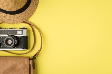 Üst görüntü fotoğraf makinesi ve deri çanta izole edilmiş sarı arkaplan ve kopyalanmış alan