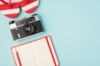 Çizgili parmak arası terliklerin üst görünümü kırmızı kalem ve izole edilmiş pastel mavi arkaplan üzerinde açık planlayıcı